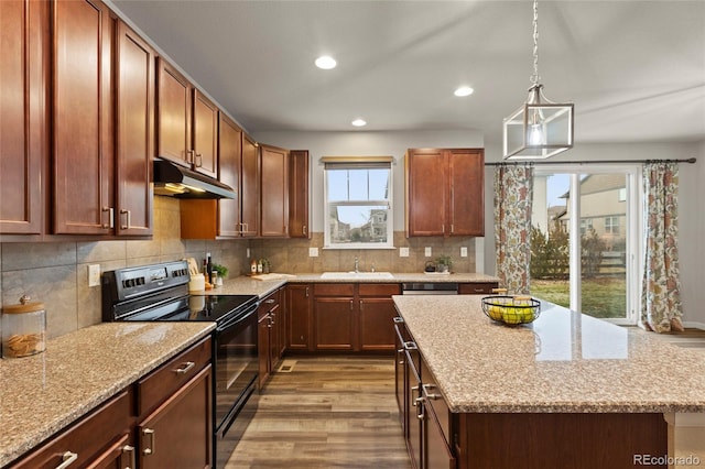 kitchen with a center island, sink, electric range, light hardwood / wood-style floors, and light stone counters