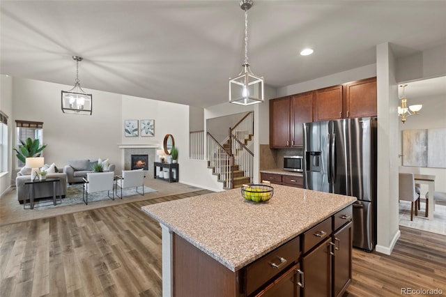 kitchen featuring pendant lighting, backsplash, dark hardwood / wood-style floors, appliances with stainless steel finishes, and a kitchen island