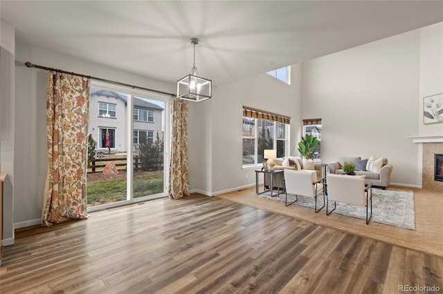 dining space with a fireplace, hardwood / wood-style floors, and an inviting chandelier