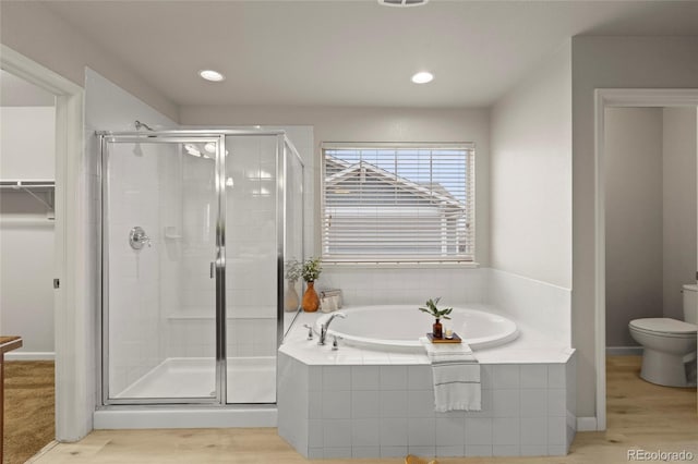 bathroom with plus walk in shower, wood-type flooring, and toilet