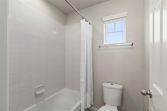 bathroom featuring shower / tub combo and toilet