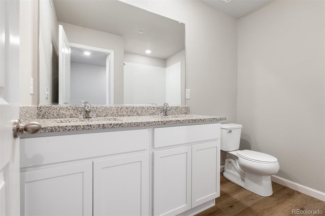 bathroom featuring a shower, wood-type flooring, vanity, and toilet