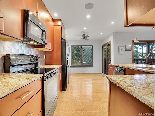 kitchen featuring sink, light stone counters, ceiling fan, light hardwood / wood-style floors, and black appliances