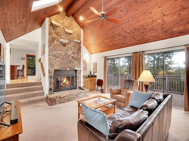 living room featuring beamed ceiling, light carpet, ceiling fan, high vaulted ceiling, and a stone fireplace