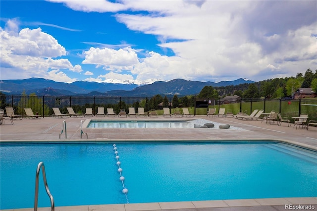 view of swimming pool featuring a patio and a mountain view