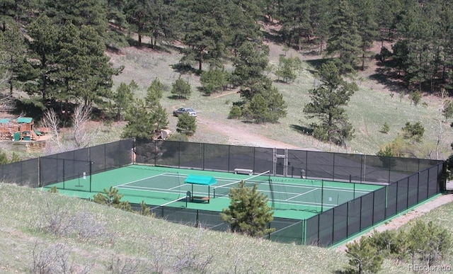 view of tennis court featuring a playground