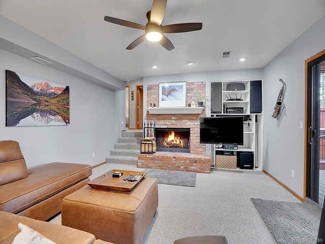 living room with ceiling fan, a brick fireplace, and carpet