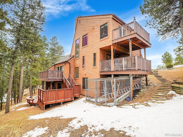 snow covered property with a wooden deck