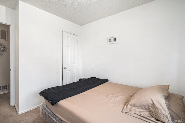 bedroom featuring baseboards, a textured ceiling, and light colored carpet