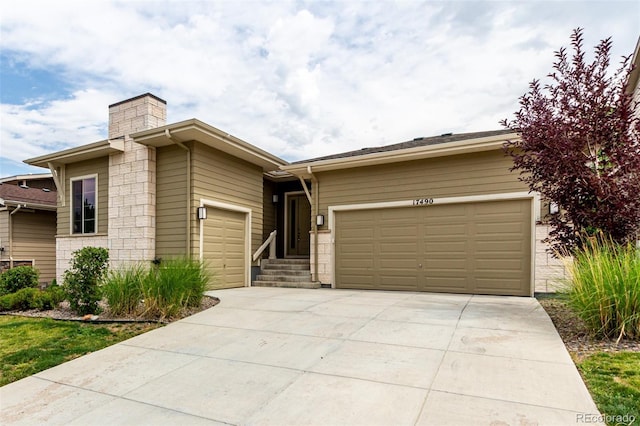 17490 W 94th Dr, Arvada, CO 80007 - view of front of home with a garage, concrete driveway, and a chimney