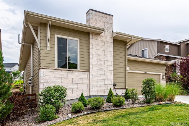 17490 W 94th Dr, Arvada, CO 80007 - view of side of property with a chimney, a garage, and stone siding