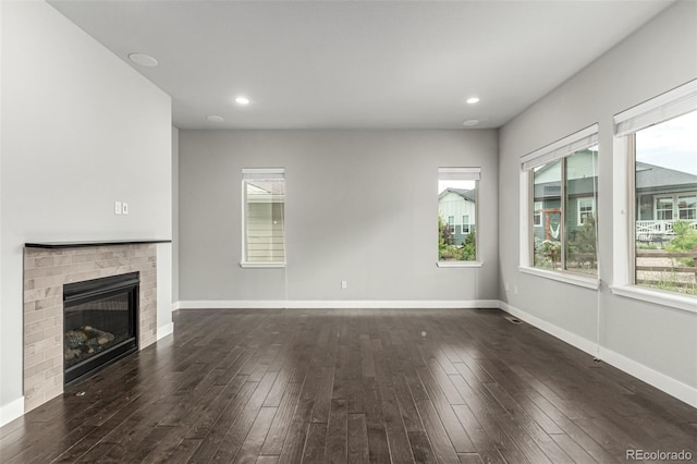 17490 W 94th Dr, Arvada, CO 80007 - unfurnished living room featuring plenty of natural light, hardwood / wood-style flooring, a fireplace, and recessed lighting