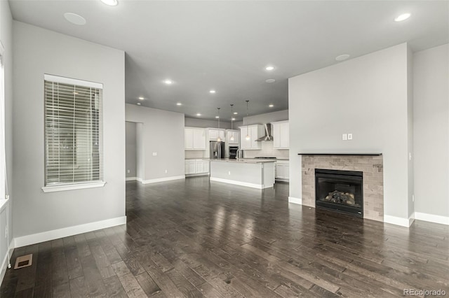 17490 W 94th Dr, Arvada, CO 80007 - unfurnished living room featuring dark wood-style floors, recessed lighting, and a glass covered fireplace