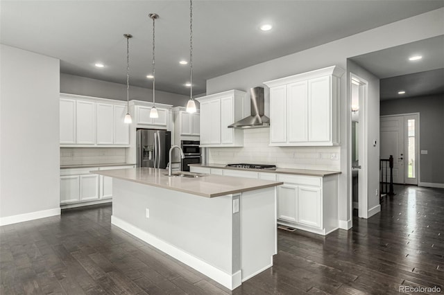 17490 W 94th Dr, Arvada, CO 80007 - kitchen with wall chimney exhaust hood, appliances with stainless steel finishes, decorative backsplash, dark wood-type flooring, and a center island with sink