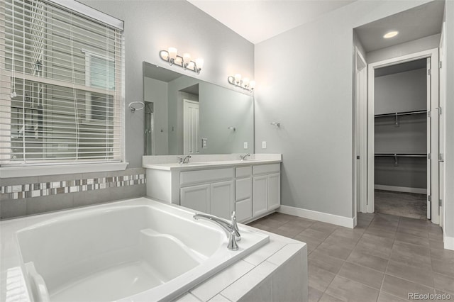 17490 W 94th Dr, Arvada, CO 80007 - bathroom featuring a bath, double vanity, tile patterned floors, and a walk in closet