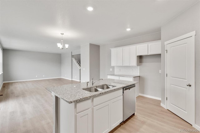 kitchen with stainless steel dishwasher, sink, a center island with sink, light hardwood / wood-style flooring, and white cabinets