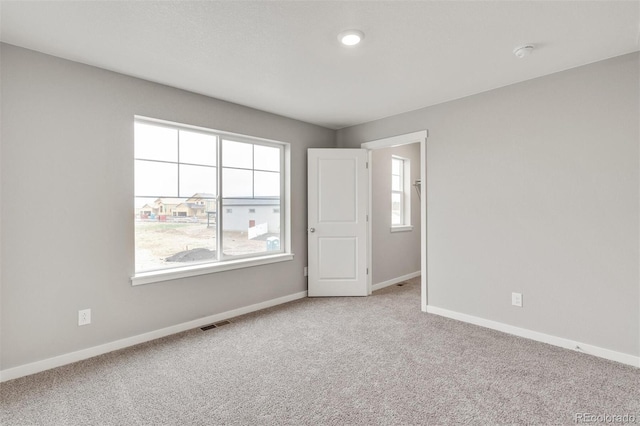 spare room featuring light colored carpet