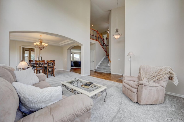 4864 Harness Ct, Parker, CO 80134 - living room with arched walkways, a chandelier, healthy amount of natural light, stairway, and a towering ceiling