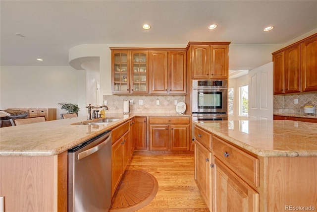4864 Harness Ct, Parker, CO 80134 - kitchen featuring appliances with stainless steel finishes, a sink, recessed lighting, light wood-style flooring, and light stone counters