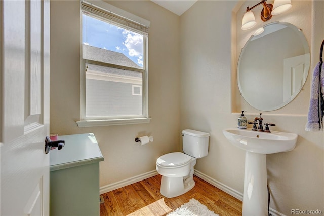 4864 Harness Ct, Parker, CO 80134 - half bath with wood finished floors, toilet, baseboards, and a sink