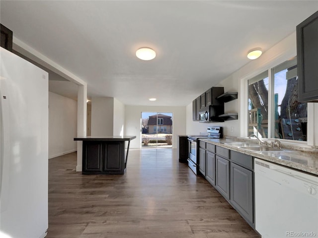 kitchen featuring a sink, open shelves, white appliances, and light wood finished floors