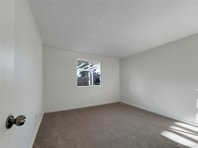 unfurnished room with baseboards and carpet flooring