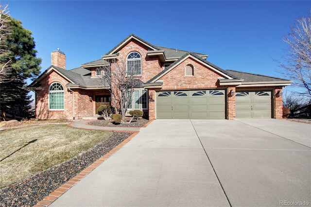 view of property featuring a garage and a front lawn