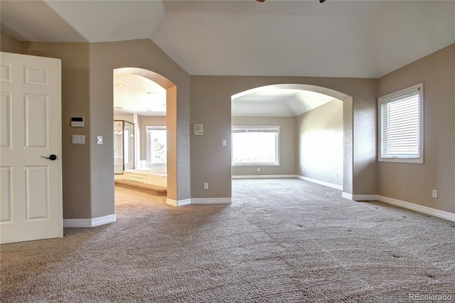 empty room featuring vaulted ceiling and light colored carpet