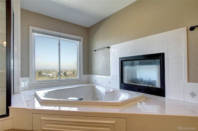 bathroom with a tiled fireplace and separate shower and tub