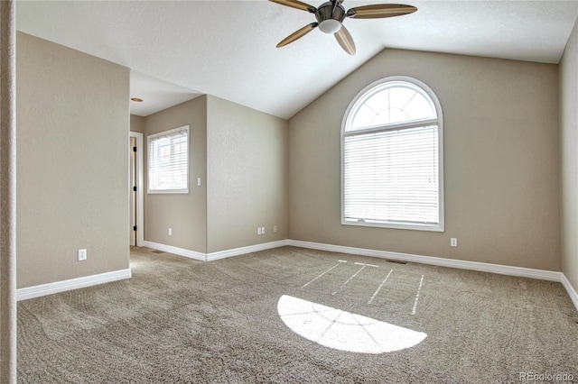 unfurnished room with light colored carpet, plenty of natural light, and vaulted ceiling