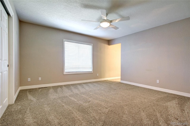 spare room with ceiling fan, carpet flooring, and a textured ceiling