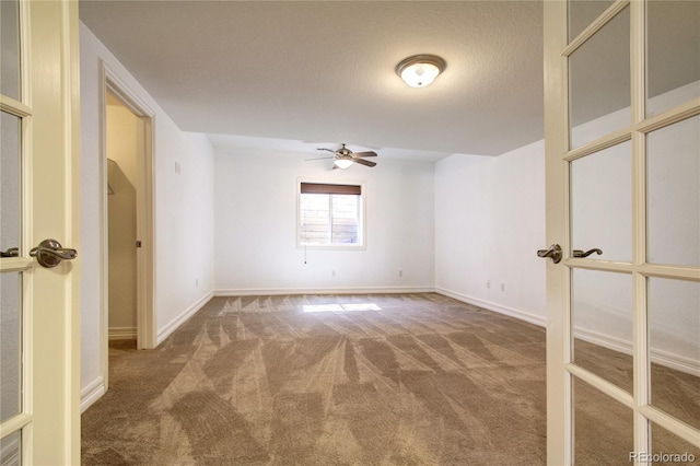 carpeted spare room with french doors, ceiling fan, and a textured ceiling