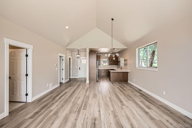 211 E Pikes Peak Ave, Woodland Park, CO 80863 - kitchen featuring light countertops, a chandelier, light wood-style flooring, open floor plan, and high vaulted ceiling