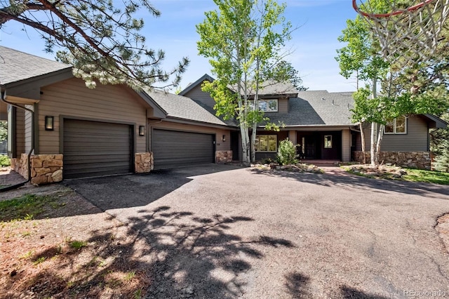 1570 Blakcomb Ct, Evergreen, CO 80439 - view of front of property featuring stone siding, a garage, asphalt driveway, and a shingled roof