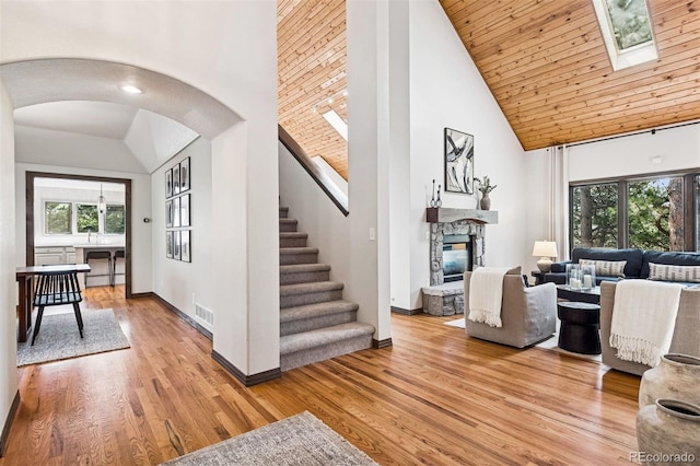 1570 Blakcomb Ct, Evergreen, CO 80439 - living room with high vaulted ceiling, arched walkways, a fireplace, stairway, and light wood finished floors