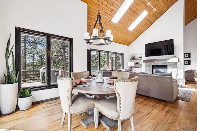 1570 Blakcomb Ct, Evergreen, CO 80439 - dining space with high vaulted ceiling, a chandelier, wood finished floors, a fireplace, and rail lighting