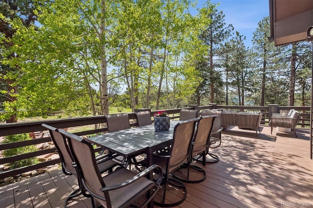 1570 Blakcomb Ct, Evergreen, CO 80439 - wooden deck featuring outdoor dining space, an outdoor living space, and view of scattered trees