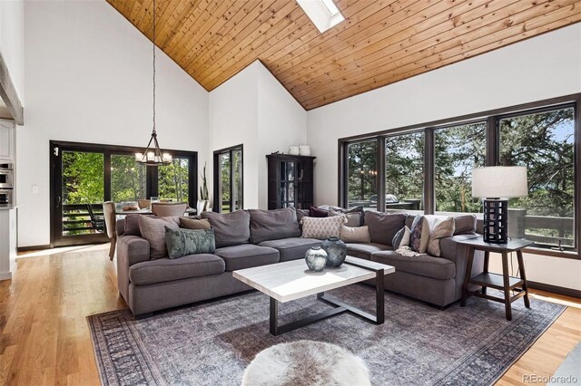 1570 Blakcomb Ct, Evergreen, CO 80439 - living room featuring high vaulted ceiling, a chandelier, light wood-style flooring, wood ceiling, and baseboards