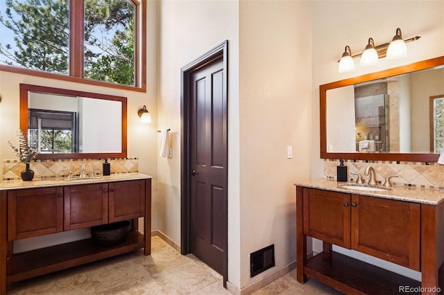 1570 Blakcomb Ct, Evergreen, CO 80439 - full bath featuring decorative backsplash, two vanities, and baseboards
