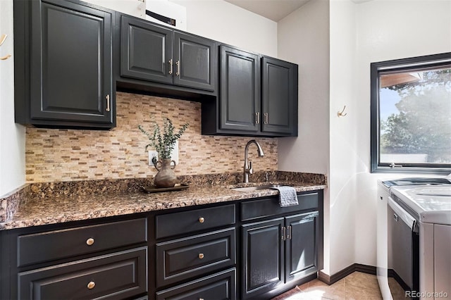 1570 Blakcomb Ct, Evergreen, CO 80439 - kitchen featuring washing machine and clothes dryer, tasteful backsplash, light tile patterned flooring, a sink, and dark cabinets