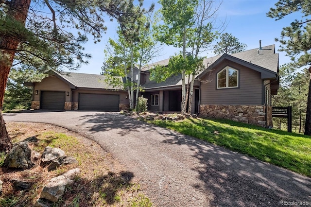 1570 Blakcomb Ct, Evergreen, CO 80439 - view of front facade with stone siding, driveway, an attached garage, roof with shingles, and a front yard