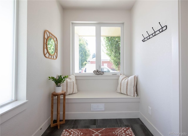 living area featuring baseboards, visible vents, and dark wood-type flooring