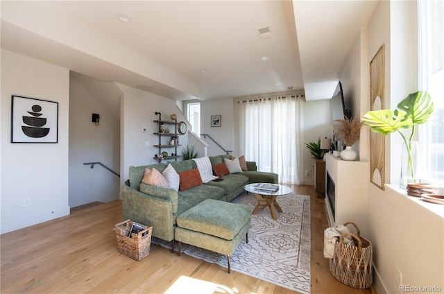 living area featuring stairs, recessed lighting, baseboards, wood finished floors, and visible vents