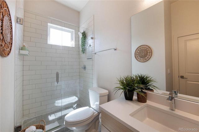 bathroom with vanity, a stall shower, and toilet