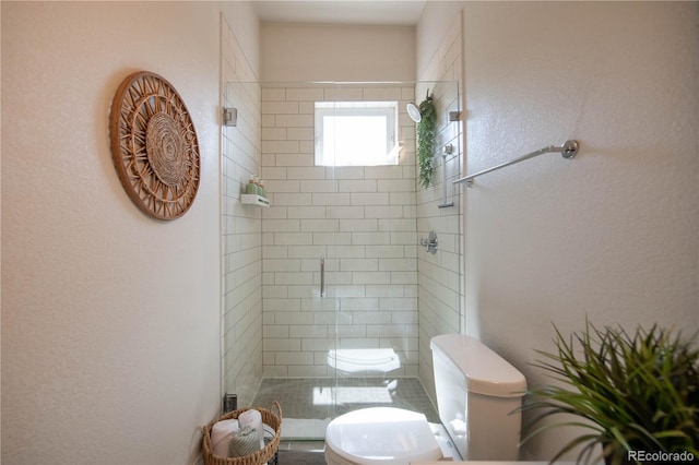 bathroom featuring a shower stall and toilet