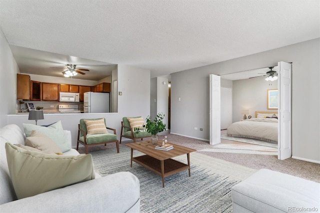 living room with light colored carpet, baseboards, and a ceiling fan