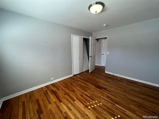 unfurnished bedroom featuring a closet and dark wood-type flooring