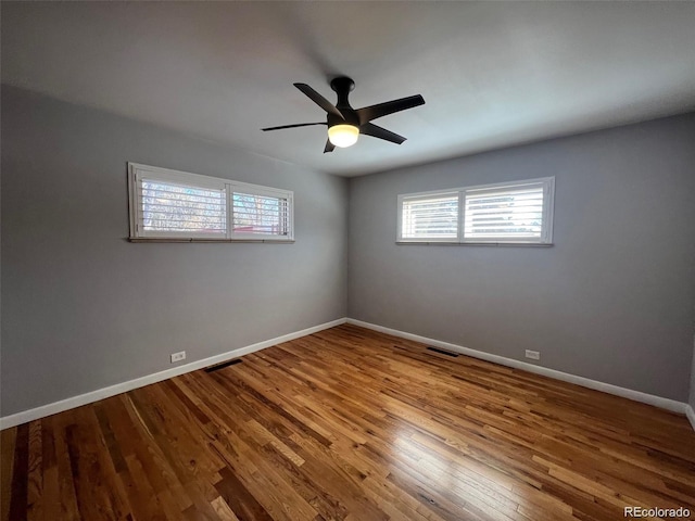 empty room with hardwood / wood-style floors and ceiling fan