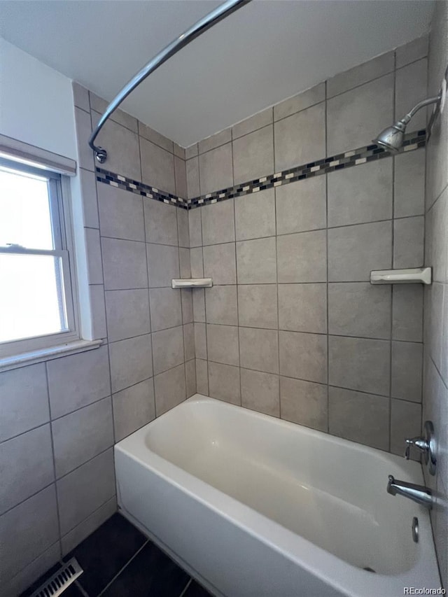 bathroom featuring tile patterned flooring and tiled shower / bath