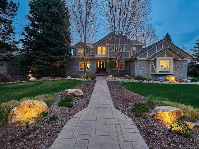 craftsman-style home with brick siding and a front yard